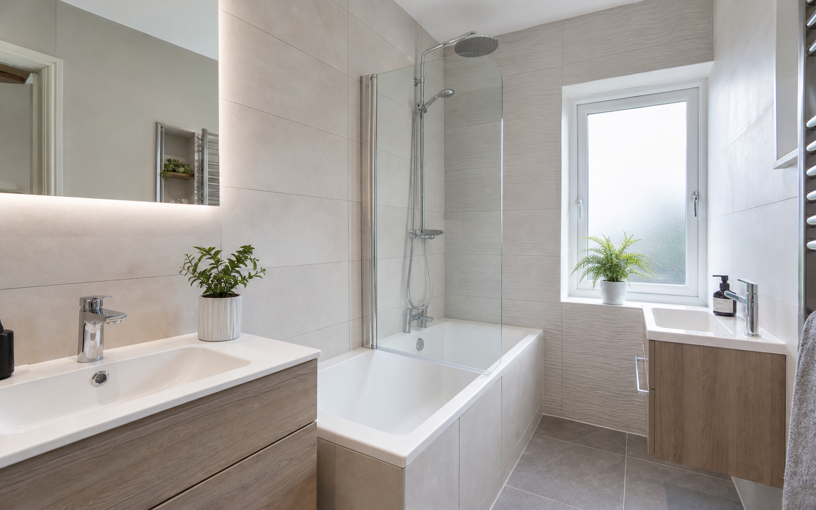Newly fitted modern bathroom suite with bath and glass screen
